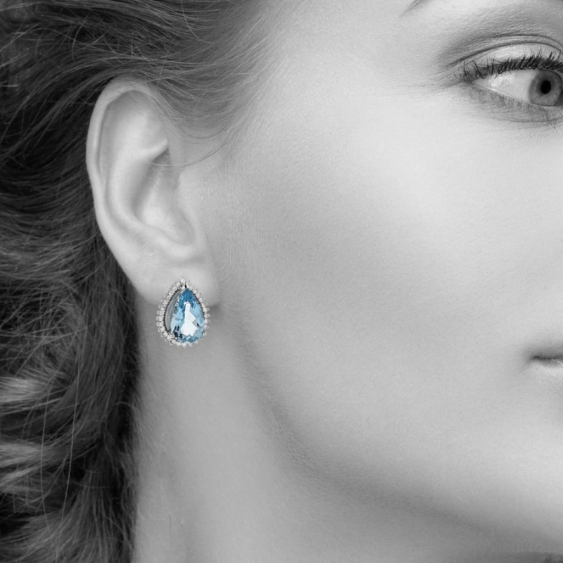 Pear Shaped Blue Topaz And Diamond Halo Stud Earrings In 14Kt White Gold